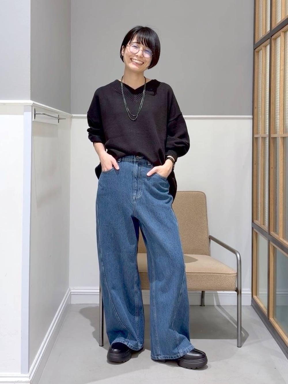 ブラック系のニット/セーター、ブラック系のステンカラーコート、ブラック系のブーツを着用したレディースの冬コーディネートの3枚目の写真