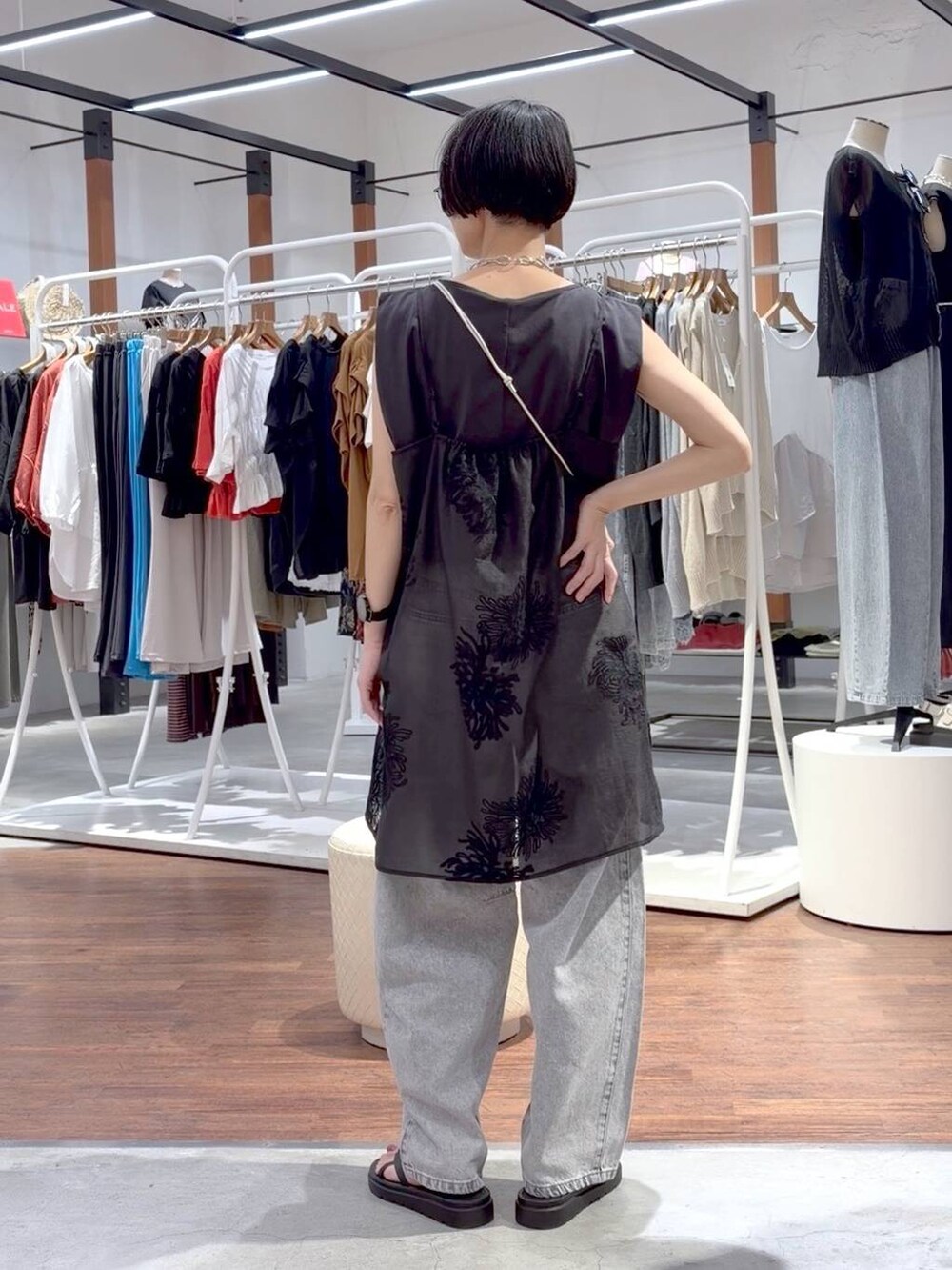 ブラック系のTシャツ/カットソー、ブラック系のサンダル、ホワイト系のショルダーバッグを着用したレディースの夏コーディネートの4枚目の写真