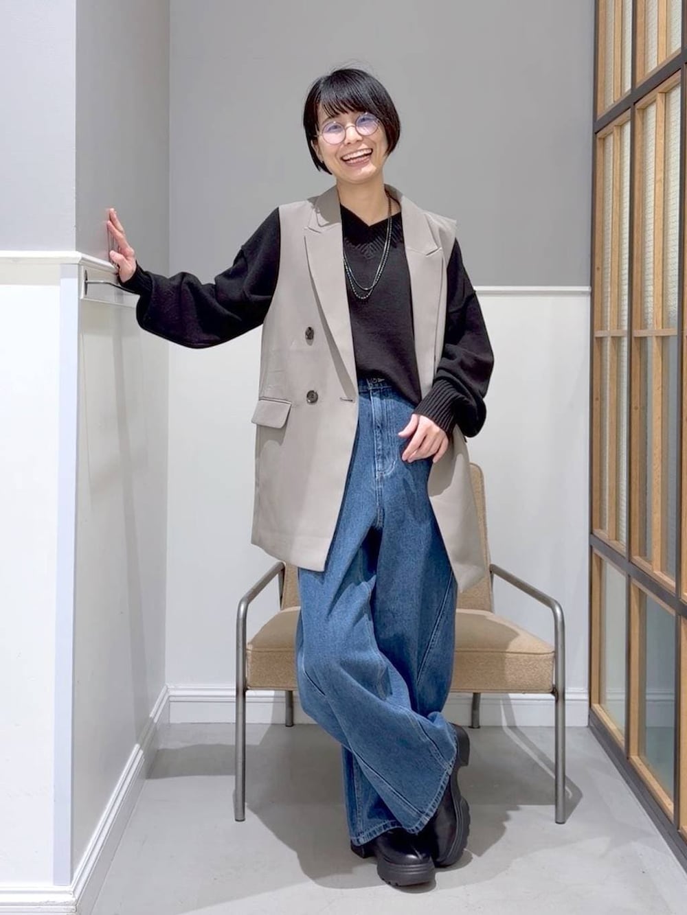 ブラック系のニット/セーター、ブラック系のステンカラーコート、ブラック系のブーツを着用したレディースの冬コーディネートの2枚目の写真