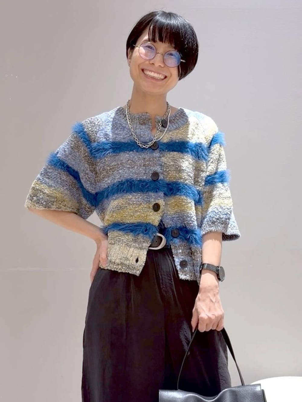 ブルー系のニット/セーター、ブラック系のその他シューズ、ブラック系のトートバッグを着用したレディースの夏コーディネートの5枚目の写真