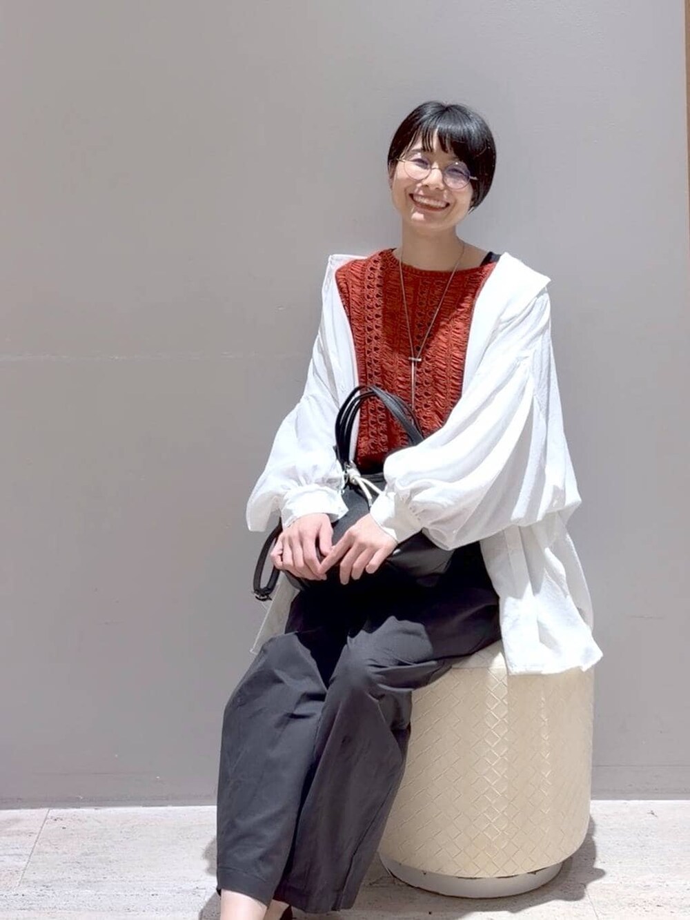 ホワイト系のシャツ/ブラウス、ブラック系のトートバッグ、ブラック系のパンプスを着用したレディースの春コーディネートの2枚目の写真