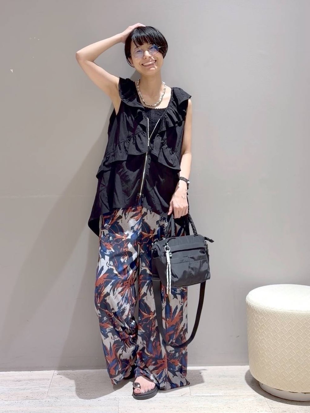 ブラック系のベスト、ホワイト系のその他パンツ、ブラック系のサンダルを着用したレディースの夏コーディネートの7枚目の写真
