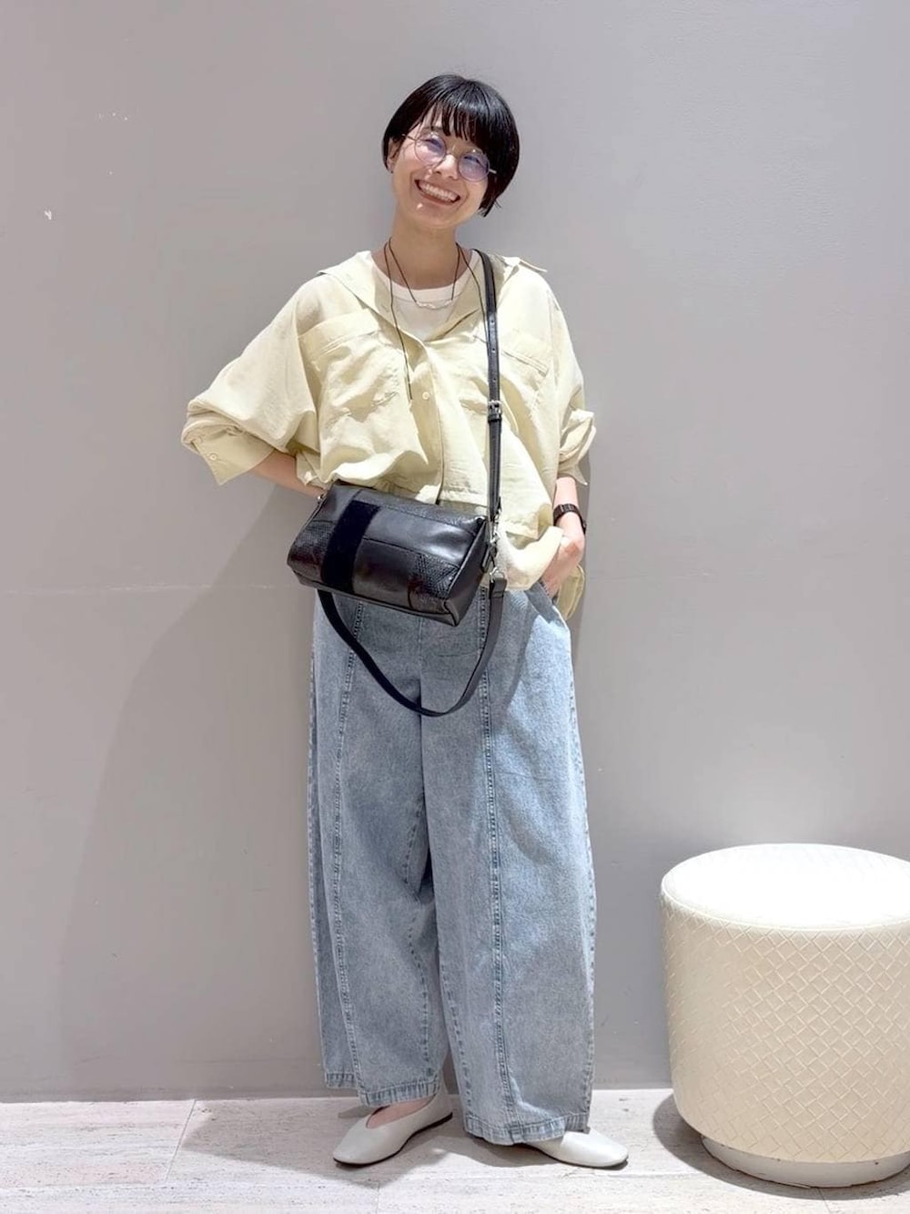 ホワイト系のパンプス、ホワイト系のタンクトップ、ブラック系のショルダーバッグを着用したレディースの春コーディネートの3枚目の写真