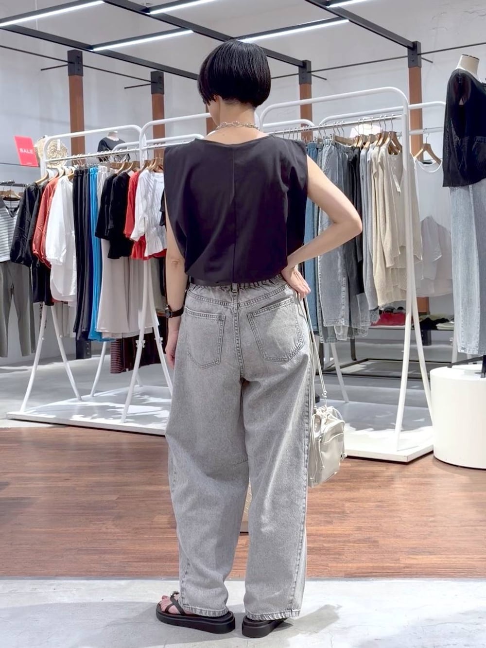 ブラック系のTシャツ/カットソー、ブラック系のサンダル、ホワイト系のショルダーバッグを着用したレディースの夏コーディネートの8枚目の写真