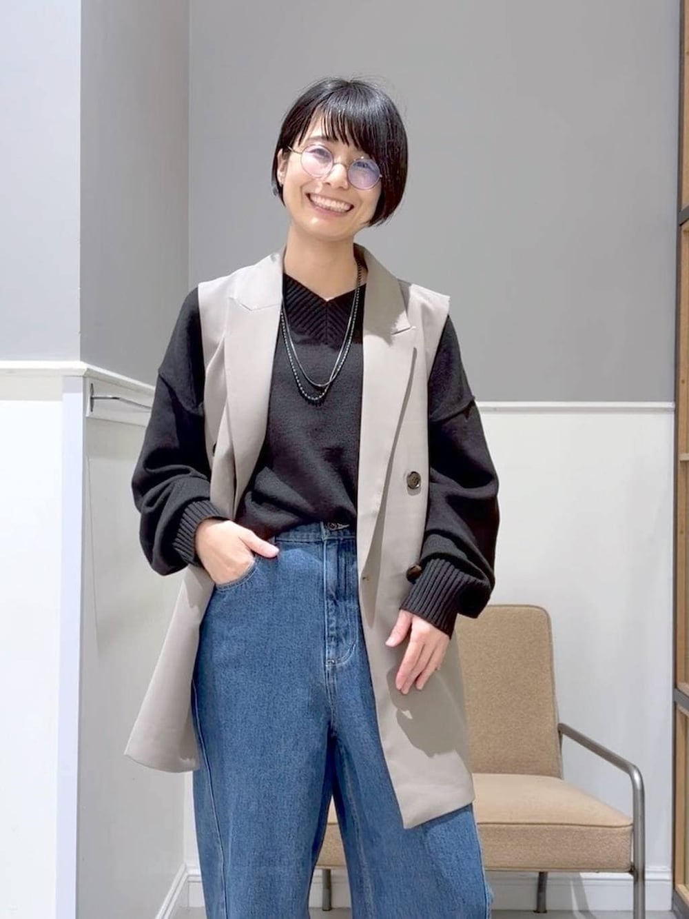 ブラック系のニット/セーター、ブラック系のステンカラーコート、ブラック系のブーツを着用したレディースの冬コーディネートの5枚目の写真