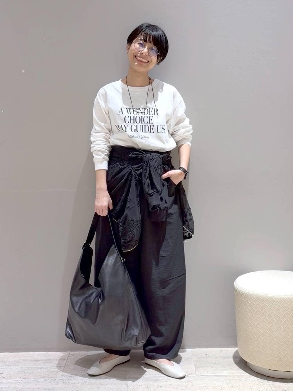 ホワイト系のパンプス、ブラック系のその他パンツ、ブラック系のショルダーバッグを着用したレディースの春コーディネートの3枚目の写真