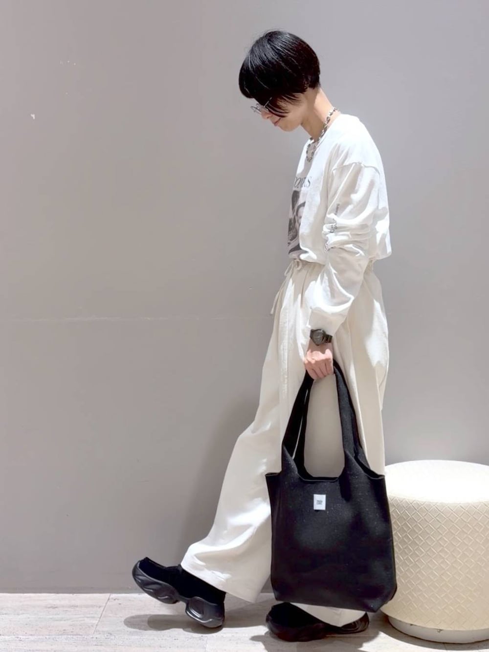 グレー系のシャツ/ブラウス、ブラック系のトートバッグ、ブラック系のスニーカーを着用したレディースの秋コーディネートの7枚目の写真