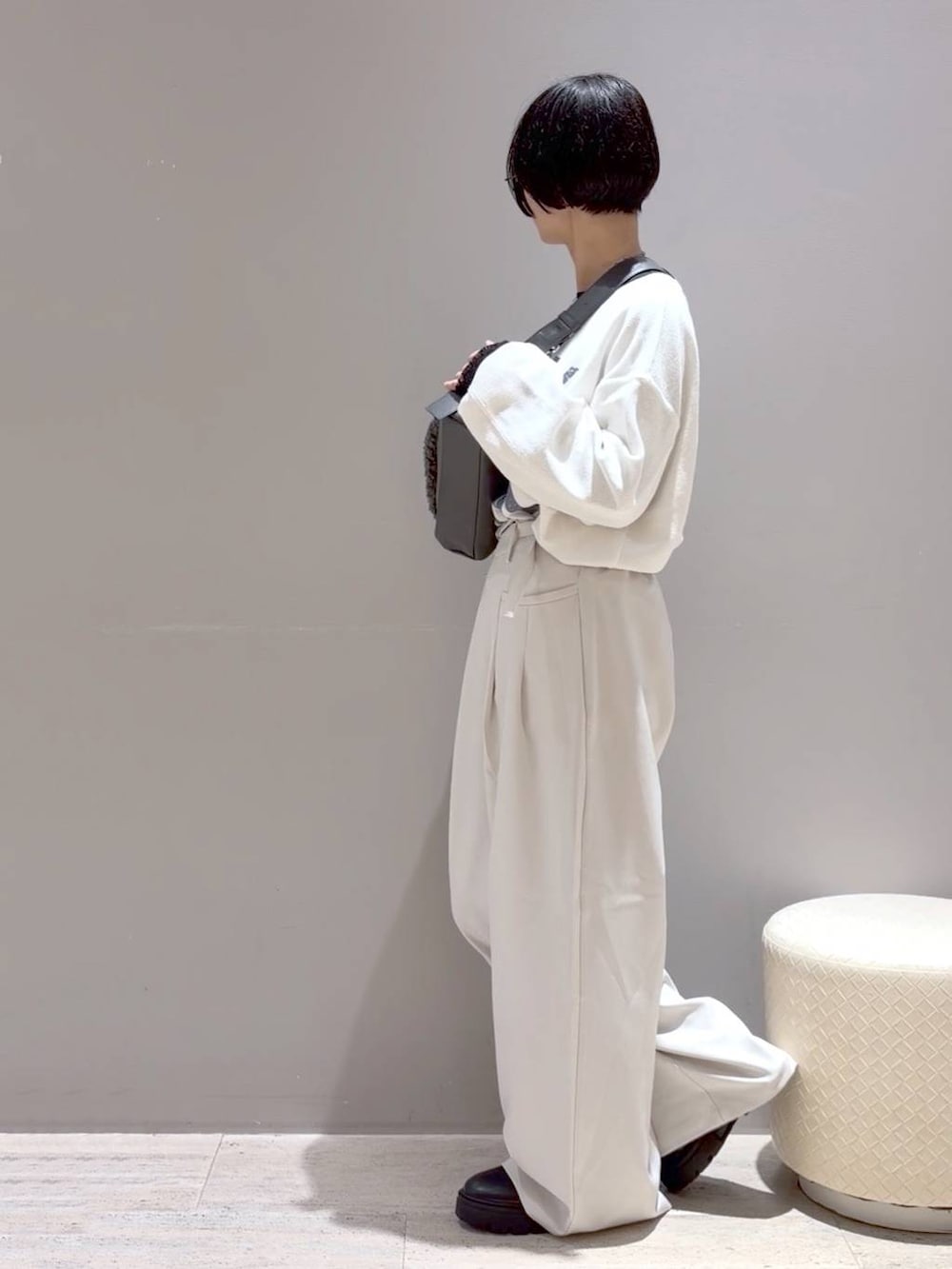 グレー系のショルダーバッグ、ホワイト系のその他パンツ、ブラック系のブーツを着用したレディースの秋コーディネートの7枚目の写真