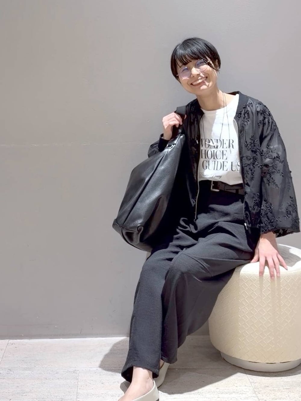 ホワイト系のパンプス、ブラック系のその他パンツ、ブラック系のショルダーバッグを着用したレディースの春コーディネートの5枚目の写真