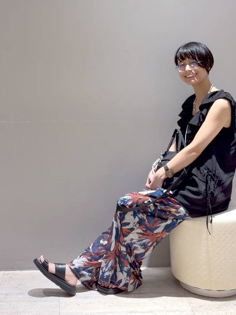 ブラック系のベスト、ホワイト系のその他パンツ、ブラック系のサンダルを着用したレディースの夏コーディネートの5枚目の写真