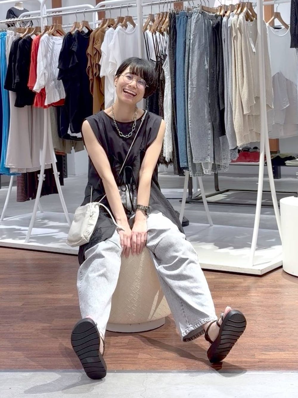 ブラック系のTシャツ/カットソー、ブラック系のサンダル、ホワイト系のショルダーバッグを着用したレディースの夏コーディネートの2枚目の写真