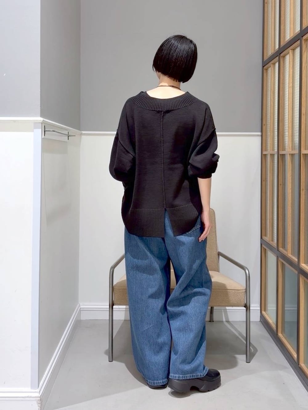 ブラック系のニット/セーター、ブラック系のステンカラーコート、ブラック系のブーツを着用したレディースの冬コーディネートの6枚目の写真