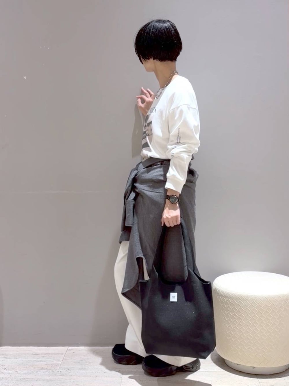 グレー系のシャツ/ブラウス、ブラック系のトートバッグ、ブラック系のスニーカーを着用したレディースの秋コーディネートの3枚目の写真