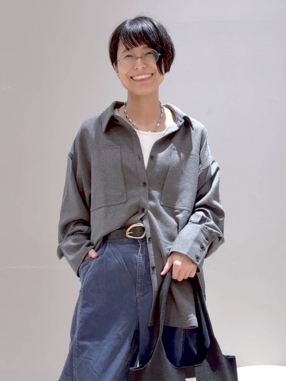 ブルー系のその他パンツ、グレー系のシャツ/ブラウス、ブラック系のトートバッグを着用したレディースの秋コーディネートの5枚目の写真