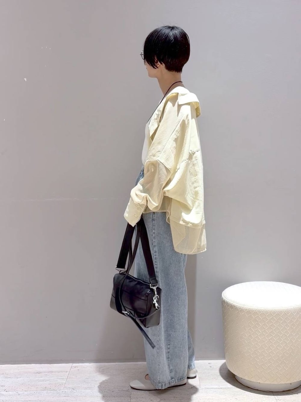 ホワイト系のパンプス、ホワイト系のタンクトップ、ブラック系のショルダーバッグを着用したレディースの春コーディネートの6枚目の写真