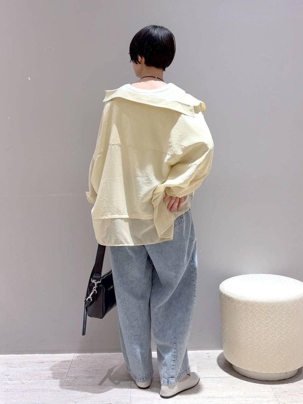 ホワイト系のパンプス、ホワイト系のタンクトップ、ブラック系のショルダーバッグを着用したレディースの春コーディネートの7枚目の写真