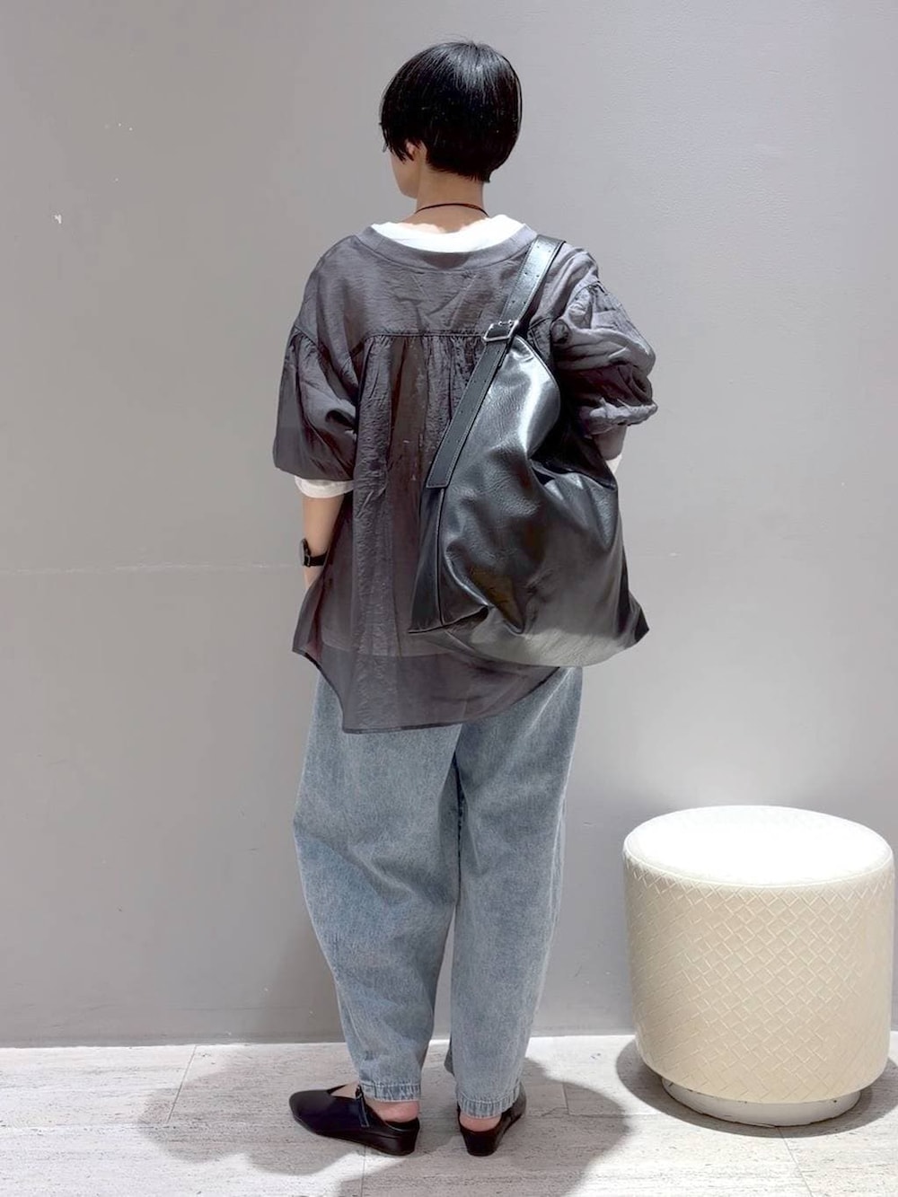 ホワイト系のTシャツ/カットソー、グレー系のシャツ/ブラウス、ブラック系のショルダーバッグを着用したレディースの春コーディネートの6枚目の写真