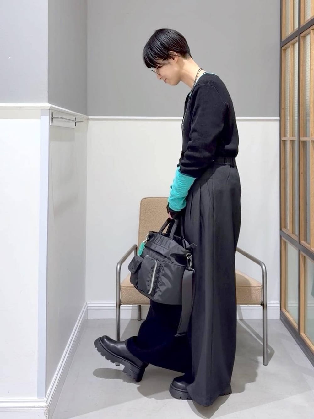 ブラック系のTシャツ/カットソー、ブラック系のトートバッグ、ブラック系のその他シューズを着用したレディースの冬コーディネートの5枚目の写真