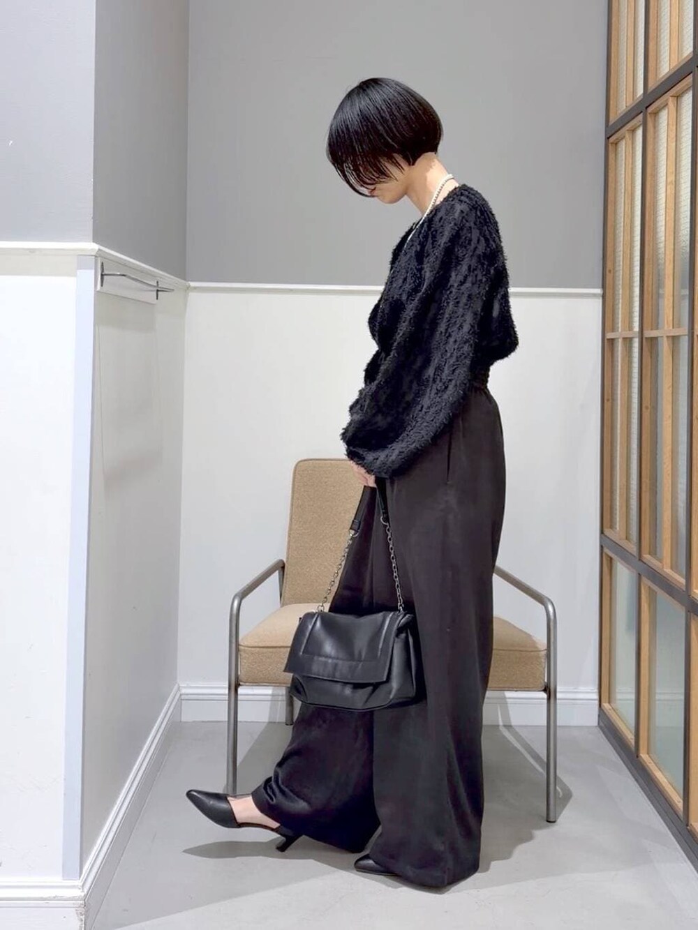 ブラウン系のステンカラーコート、ブラック系のTシャツ/カットソー、ブラック系のその他パンツを着用したレディースの冬コーディネートの5枚目の写真