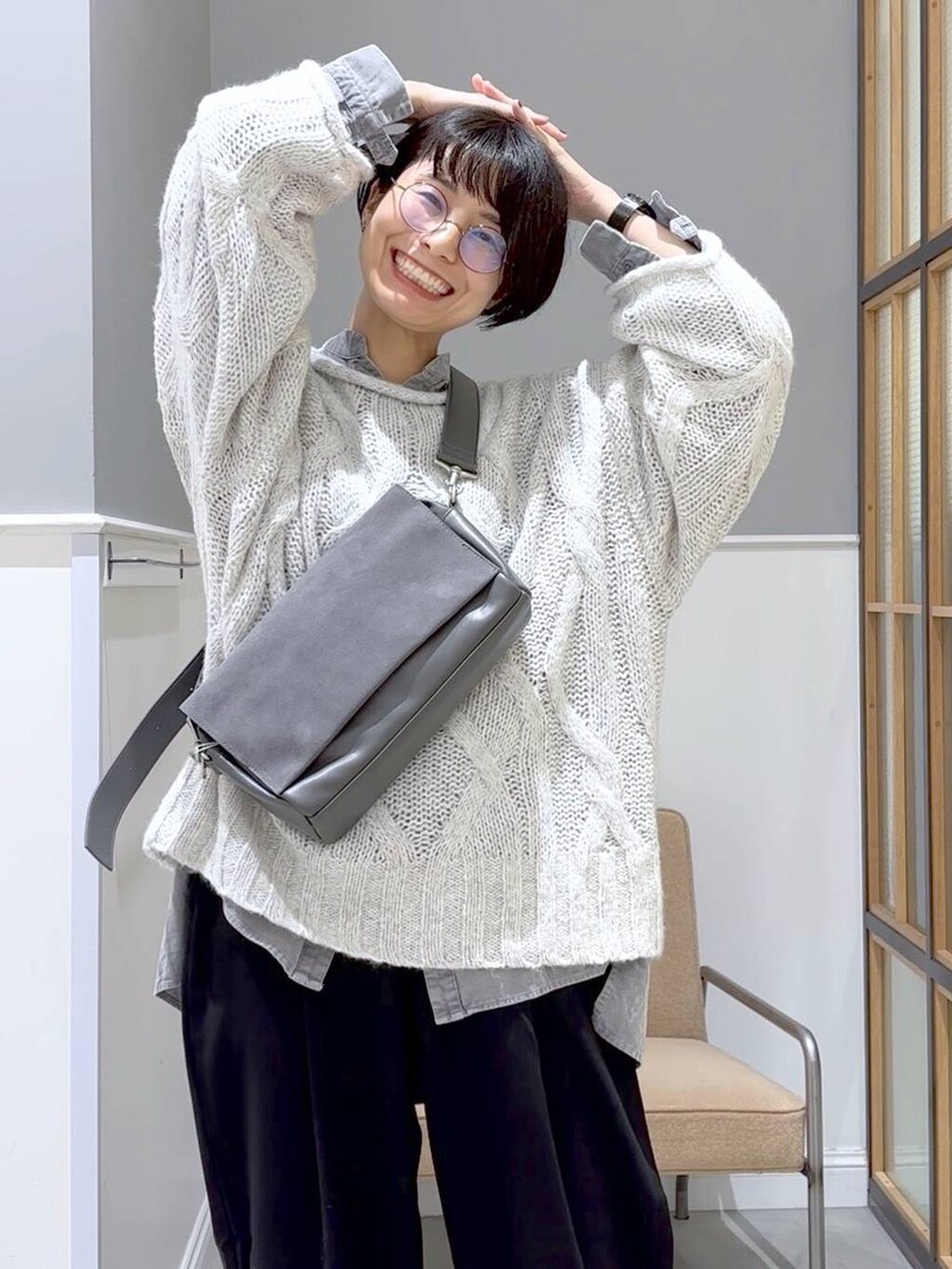 グレー系のショルダーバッグ、ブラック系のその他パンツ、グレー系のニット/セーターを着用したレディースの秋コーディネートの2枚目の写真