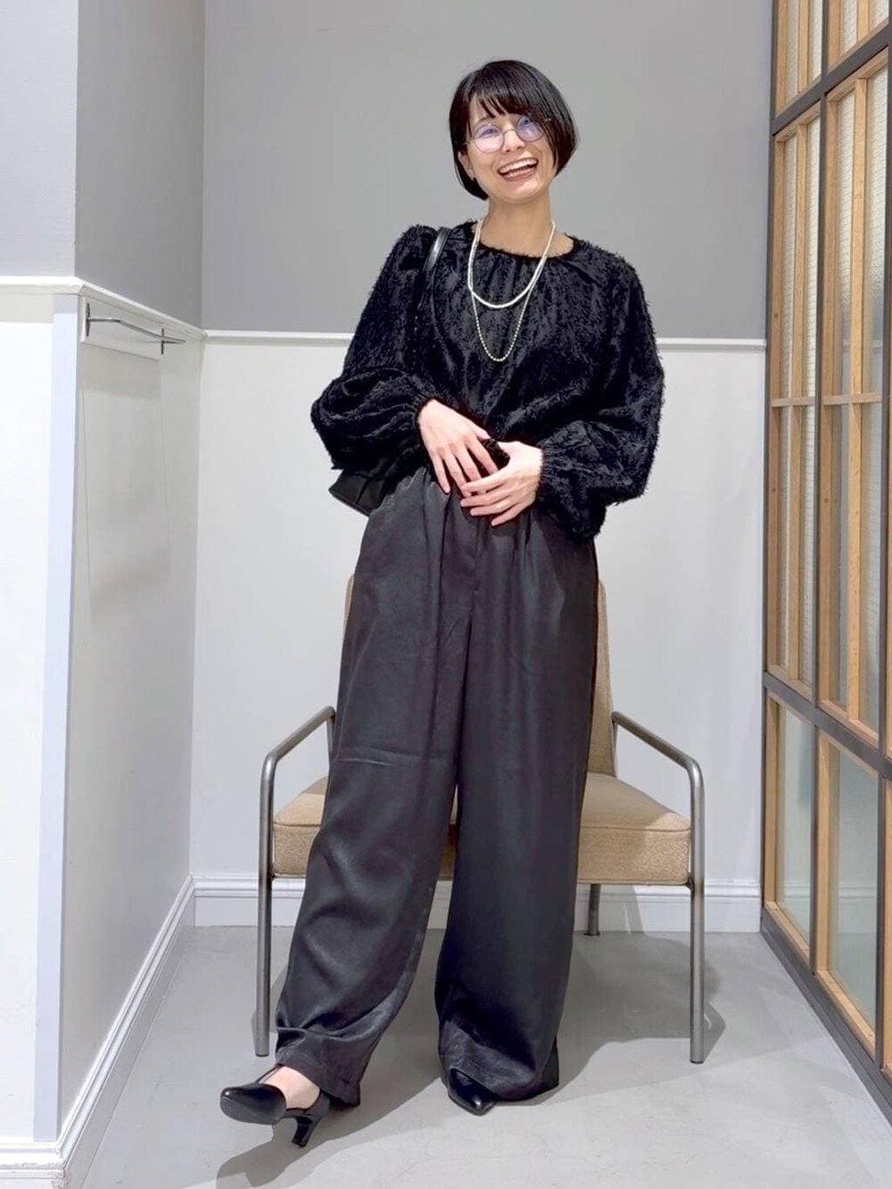 ブラウン系のステンカラーコート、ブラック系のTシャツ/カットソー、ブラック系のその他パンツを着用したレディースの冬コーディネートの3枚目の写真