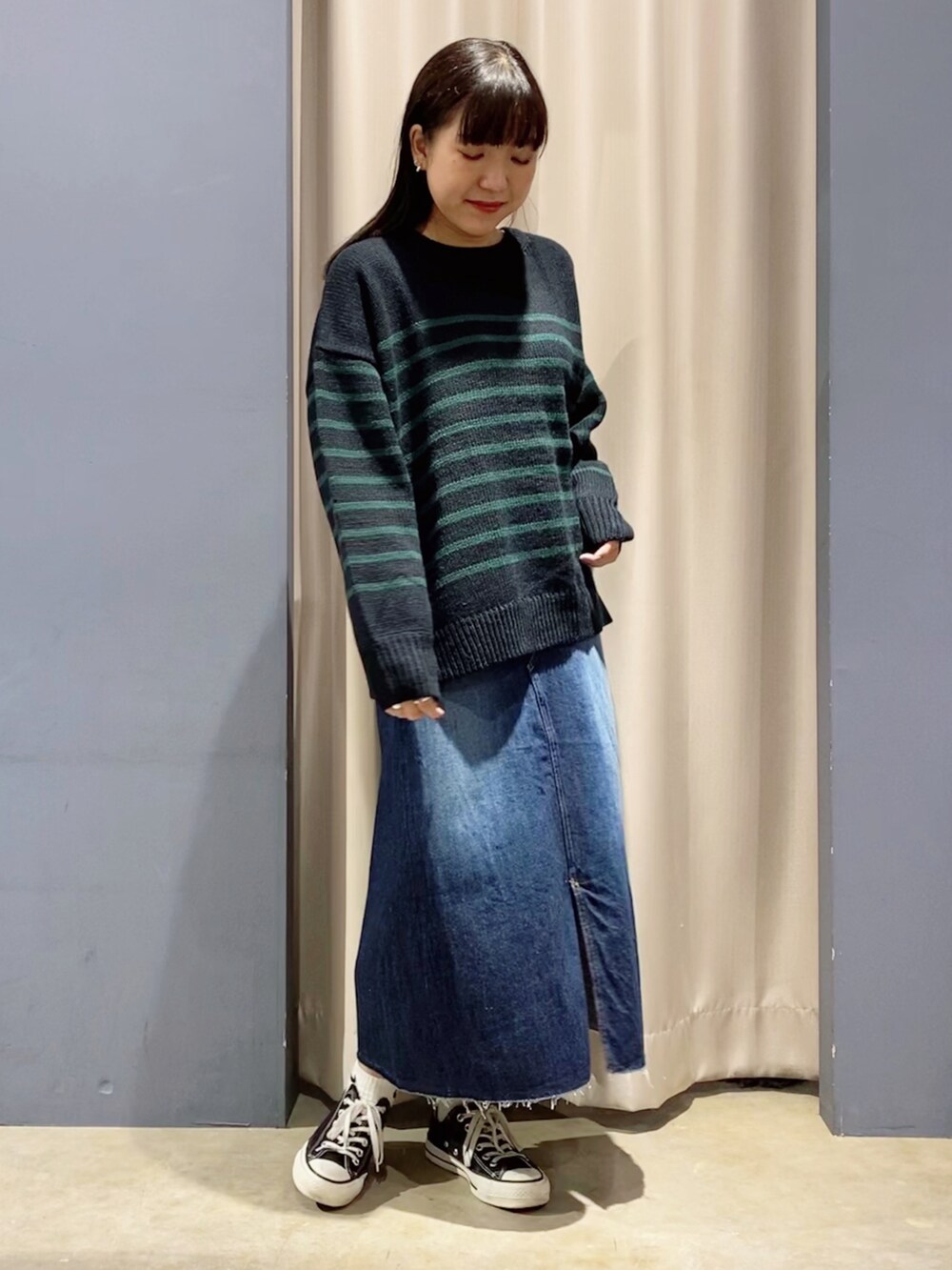 ブルー系のカーディガン/ボレロ、ブルー系のデニムスカート、ブラック系のスニーカーを着用したレディースの秋コーディネートの3枚目の写真