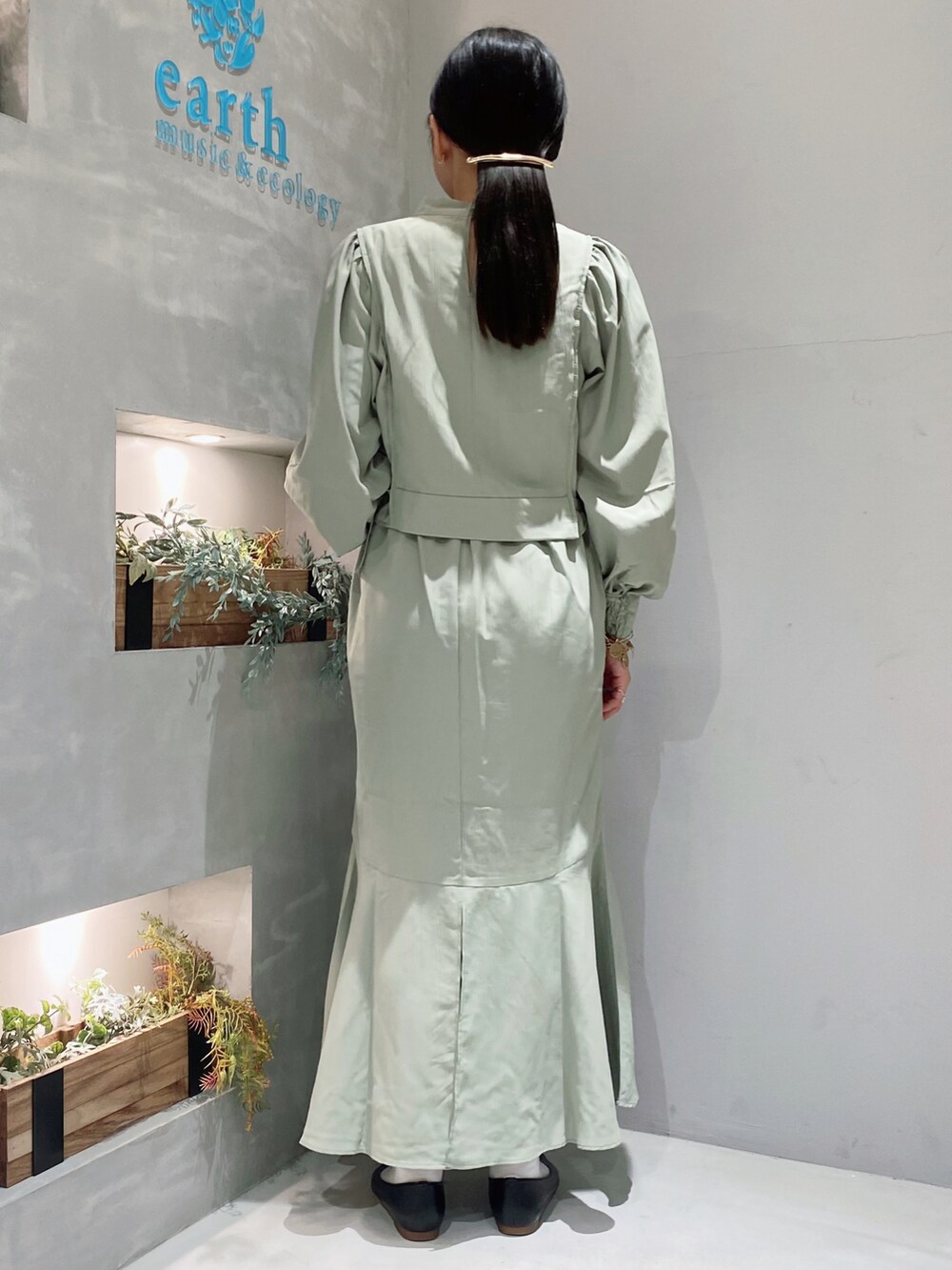 ブラック系のパンプス、グリーン系のスカートを着用したレディースの春コーディネートの2枚目の写真