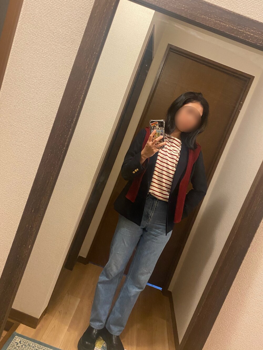 レッド系のトップス、レッド系のトップス、ブルー系のデニムパンツを着用したレディースの秋コーディネートの3枚目の写真