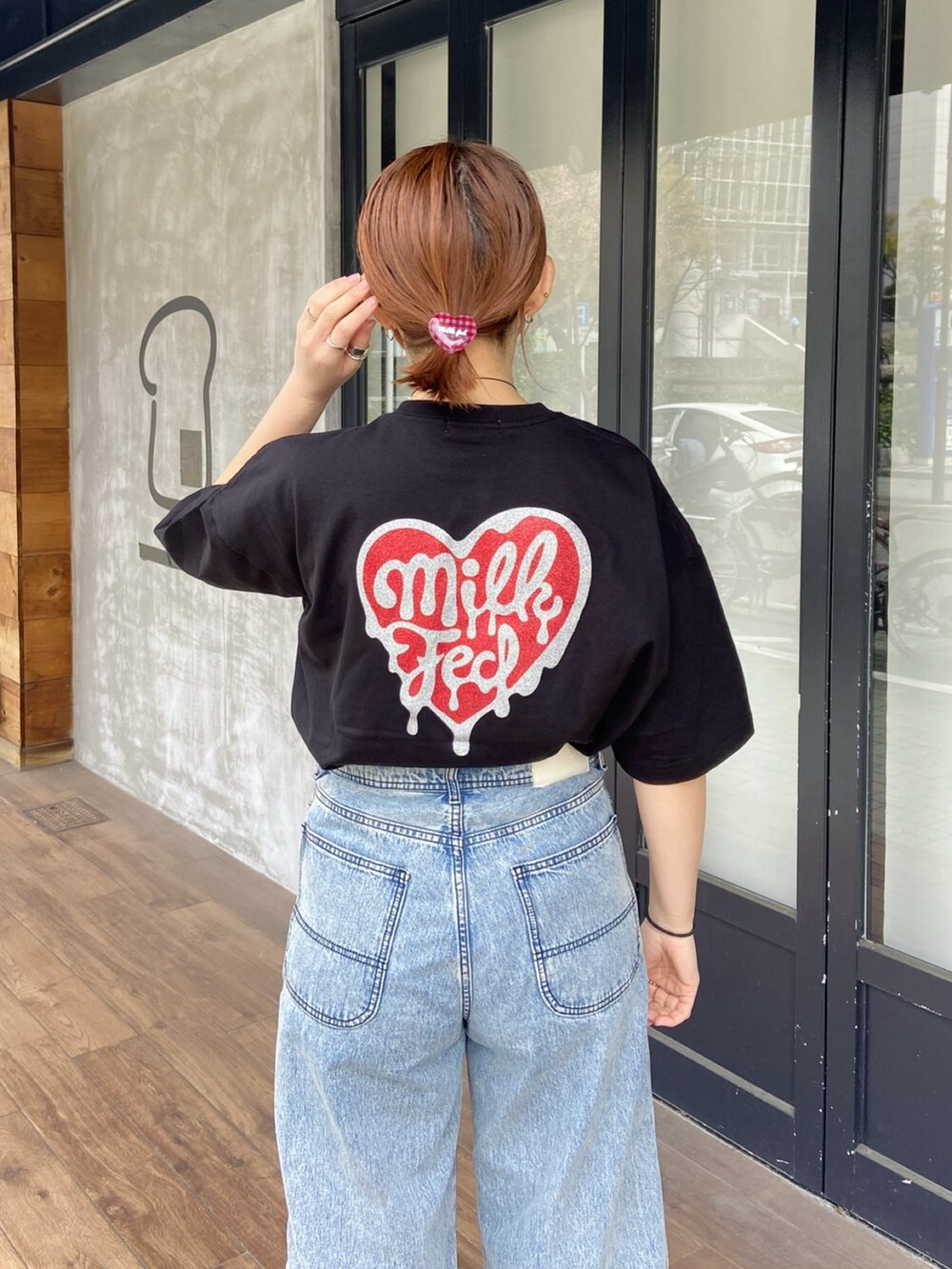 ブラック系のTシャツ/カットソー、ブルー系のデニムパンツ、レッド系のヘアゴムを着用したレディースの春コーディネートの4枚目の写真