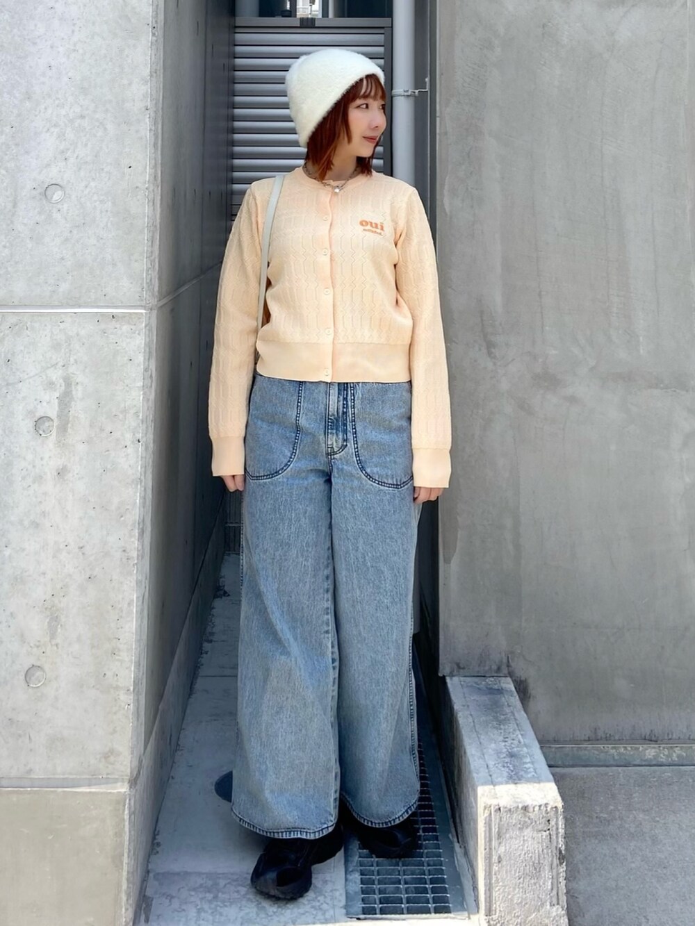 イエロー系のカーディガン/ボレロ、ブルー系のデニムパンツを着用したレディースの春コーディネートの4枚目の写真