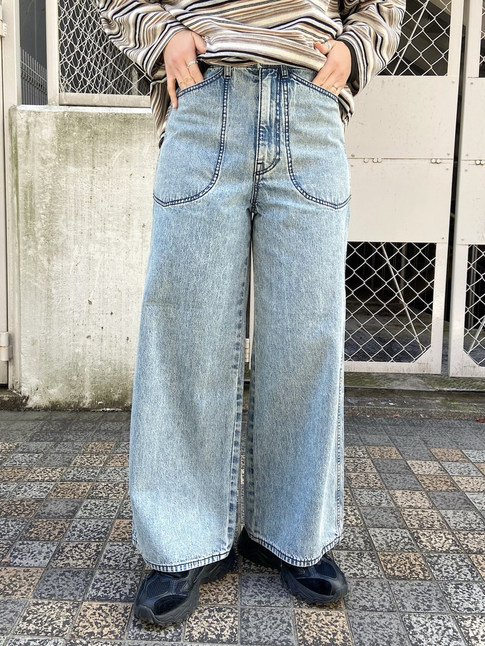 ベージュ系のポロシャツ、ブルー系のデニムパンツを着用したレディースの冬コーディネートの4枚目の写真