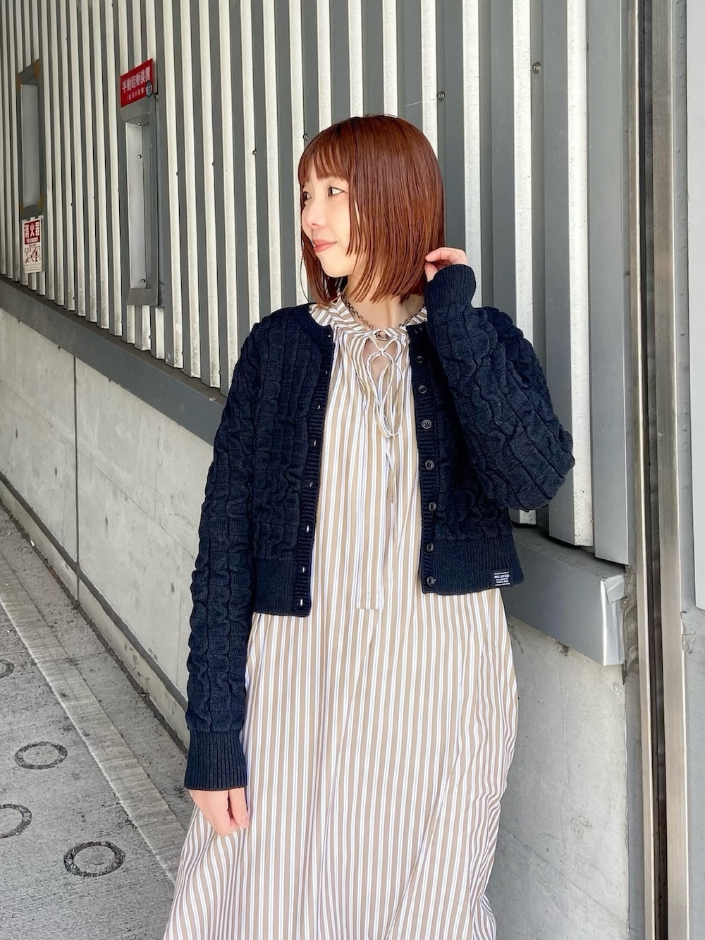 ベージュ系のシャツワンピース、ブラック系のカーディガン/ボレロを着用したレディースの春コーディネートの3枚目の写真