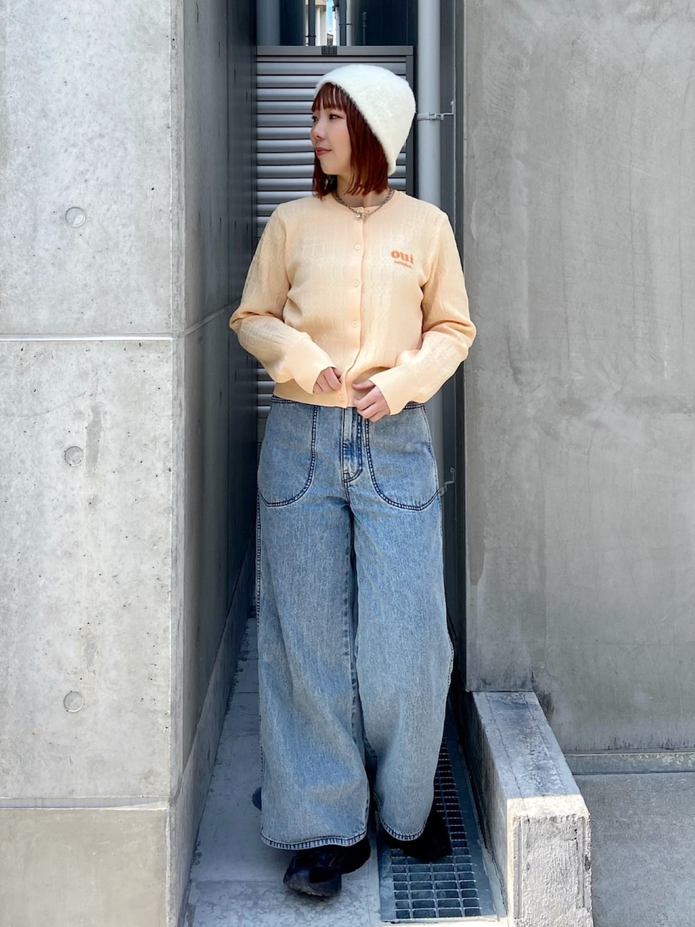 イエロー系のカーディガン/ボレロ、ブルー系のデニムパンツを着用したレディースの春コーディネートの2枚目の写真