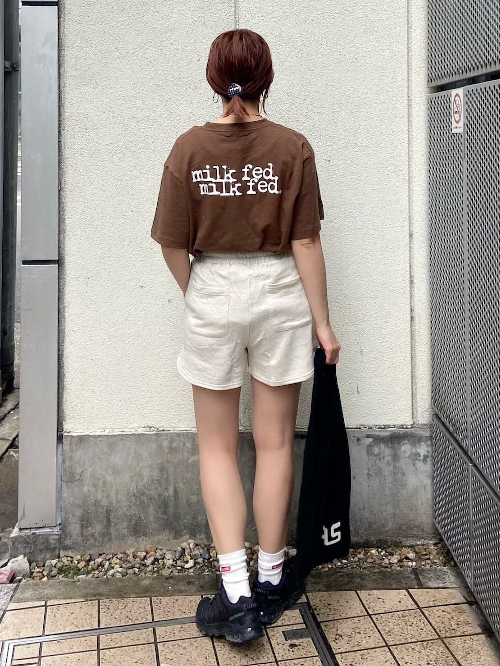 ブラウン系のTシャツ/カットソー、ベージュ系のスウェットパンツ、ブラック系のトートバッグを着用したレディースの春コーディネートの2枚目の写真