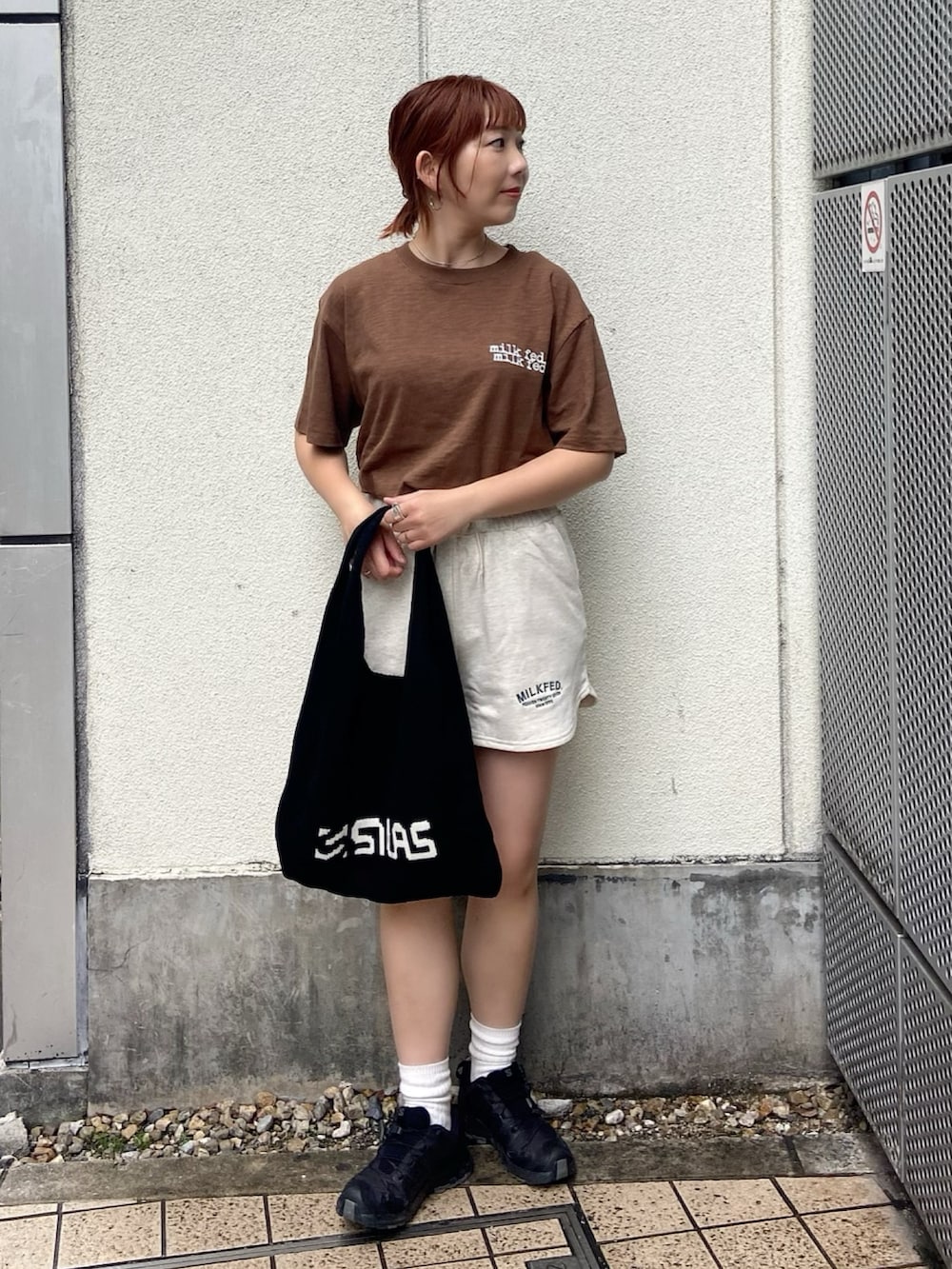 ブラウン系のTシャツ/カットソー、ベージュ系のスウェットパンツ、ブラック系のトートバッグを着用したレディースの春コーディネートの3枚目の写真