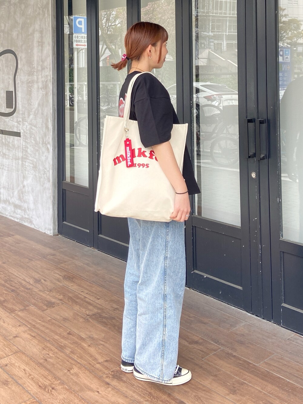 ブラック系のTシャツ/カットソー、ブルー系のデニムパンツ、レッド系のヘアゴムを着用したレディースの春コーディネートの5枚目の写真