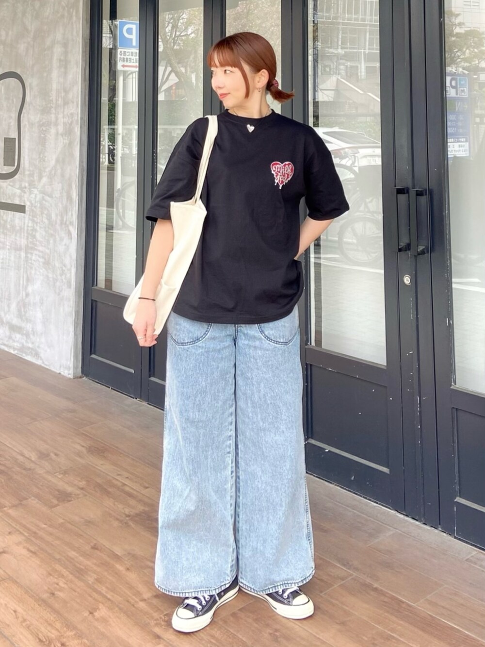 ブラック系のTシャツ/カットソー、ブルー系のデニムパンツ、レッド系のヘアゴムを着用したレディースの春コーディネートの2枚目の写真