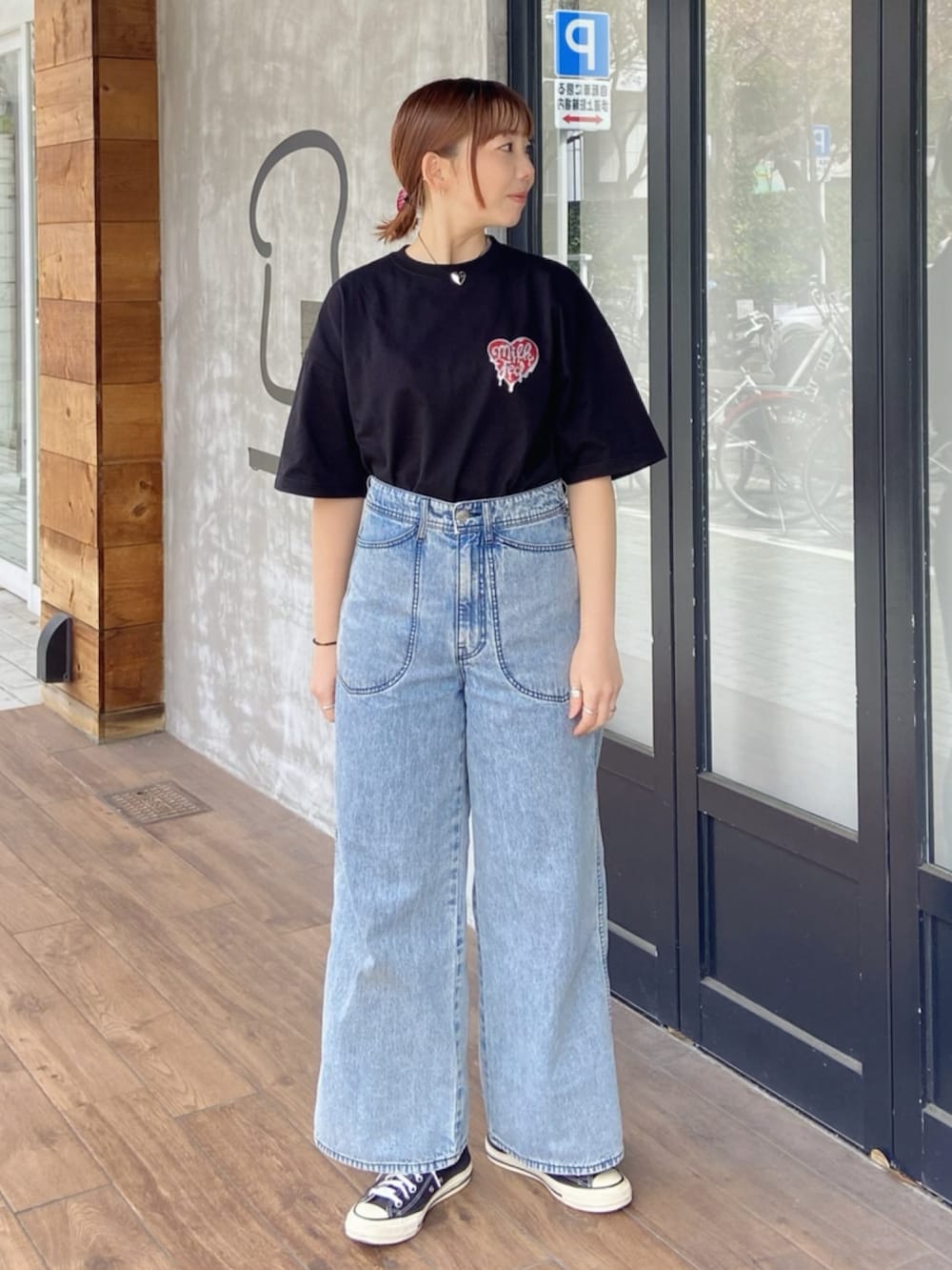 ブラック系のTシャツ/カットソー、ブルー系のデニムパンツ、レッド系のヘアゴムを着用したレディースの春コーディネートの3枚目の写真