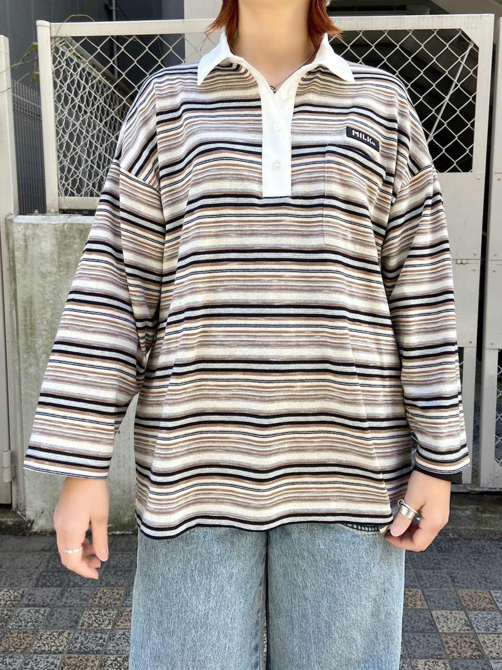 ベージュ系のポロシャツ、ブルー系のデニムパンツを着用したレディースの冬コーディネートの3枚目の写真