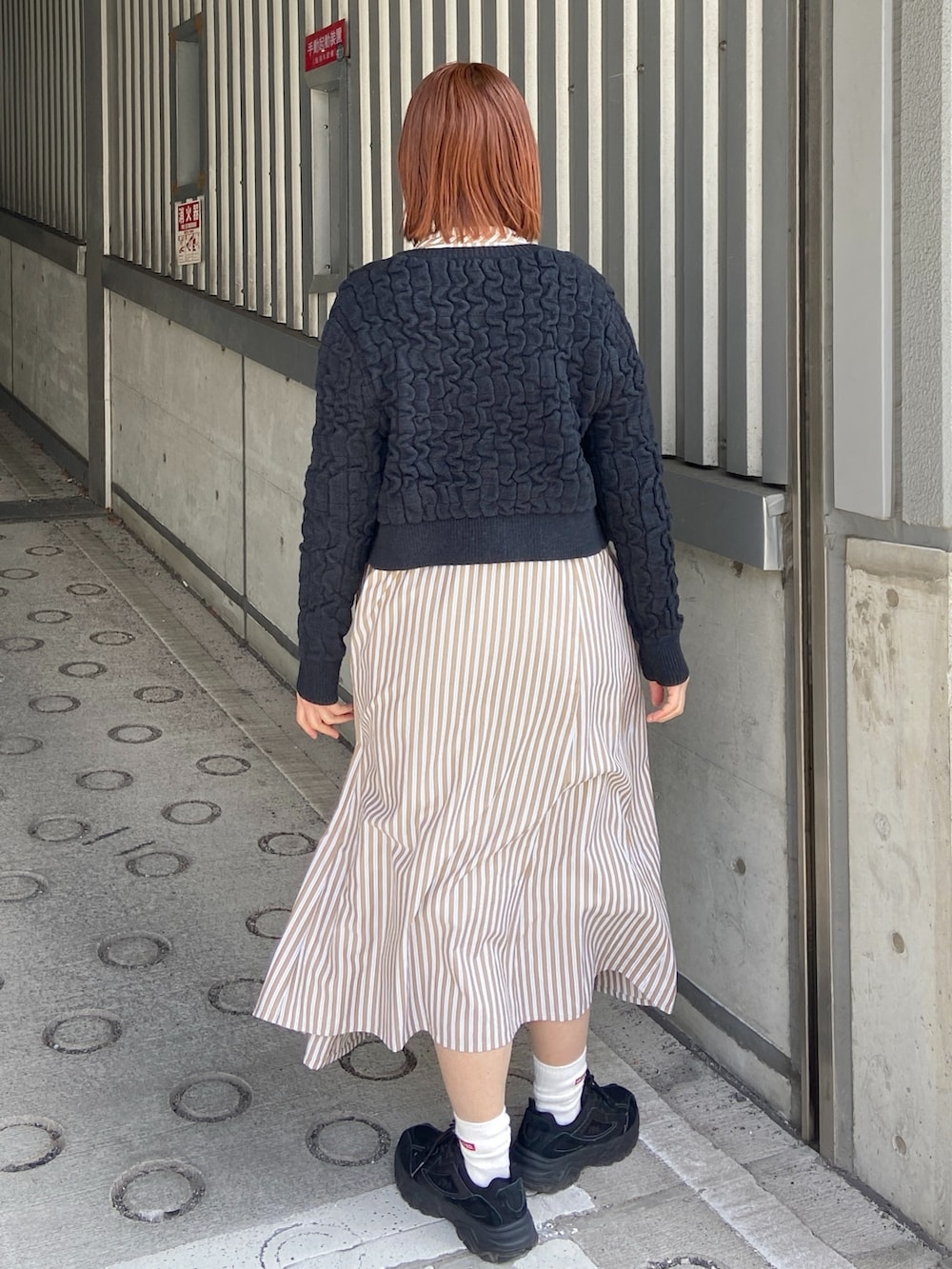 ベージュ系のシャツワンピース、ブラック系のカーディガン/ボレロを着用したレディースの春コーディネートの4枚目の写真