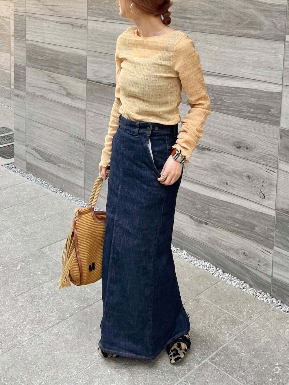 ブルー系のデニムスカート、ベージュ系のトートバッグ、イエロー系のバレエシューズを着用したレディースの春コーディネートの3枚目の写真