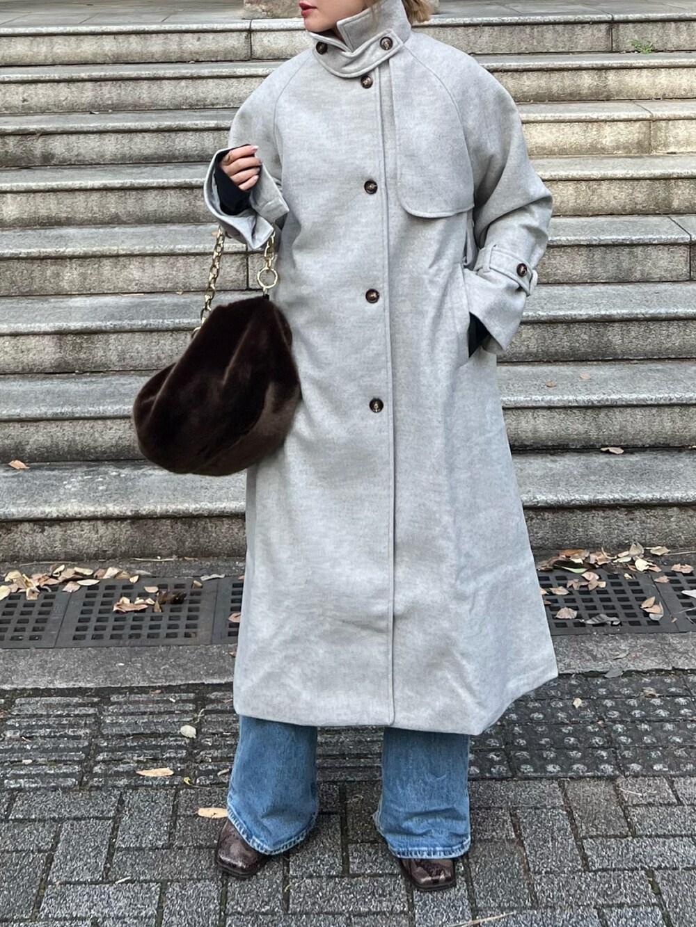 ベージュ系のトレンチコート、ブラウン系のニット/セーター、ブラウン系のバッグを着用したレディースの冬コーディネートの3枚目の写真