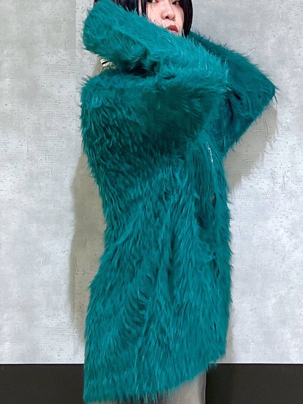 ブラック系のブーツ、グリーン系のカーディガン/ボレロ、ブラック系のスカートを着用したレディースの秋コーディネートの5枚目の写真