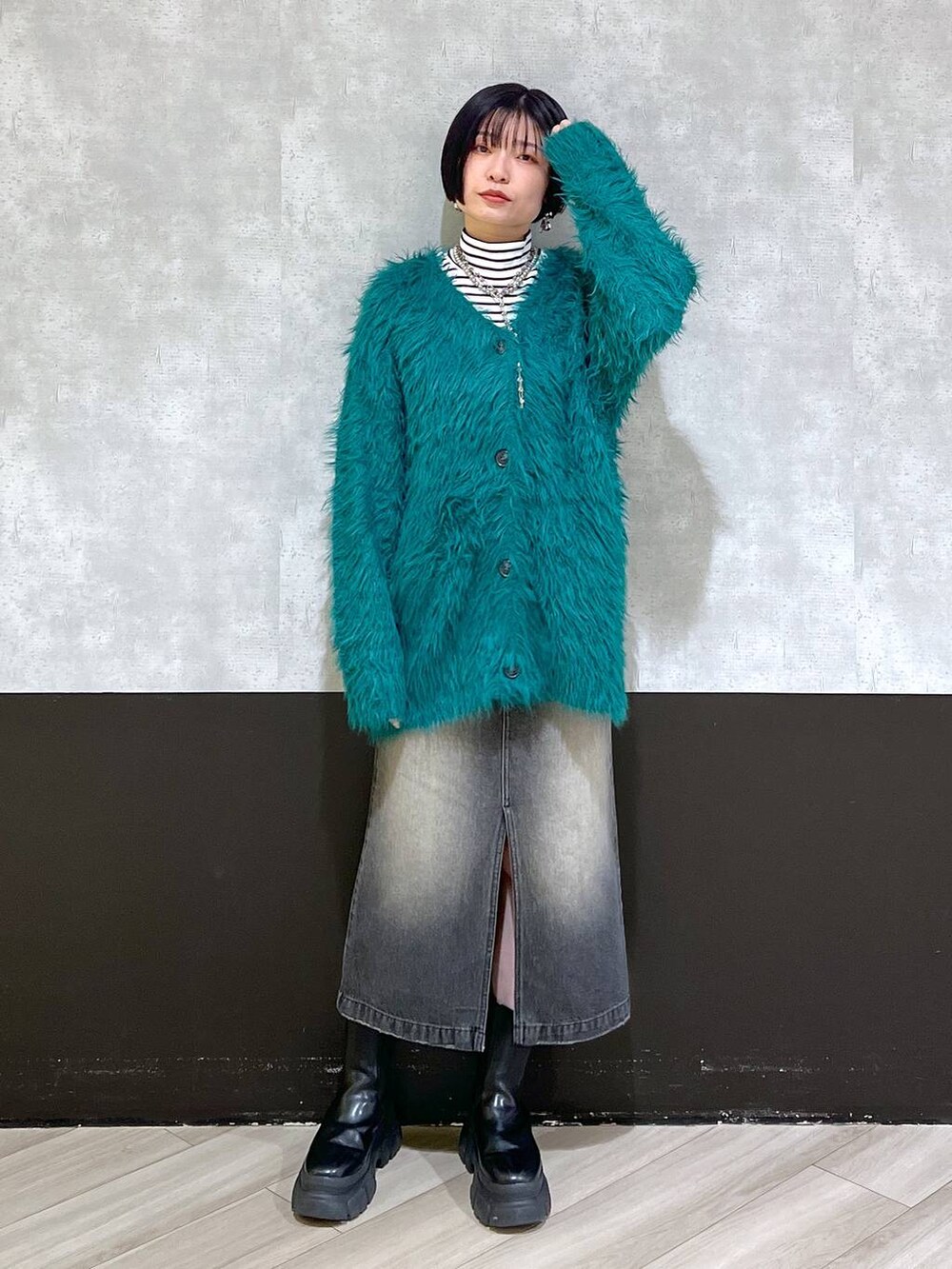 ブラック系のブーツ、グリーン系のカーディガン/ボレロ、ブラック系のスカートを着用したレディースの秋コーディネートの7枚目の写真