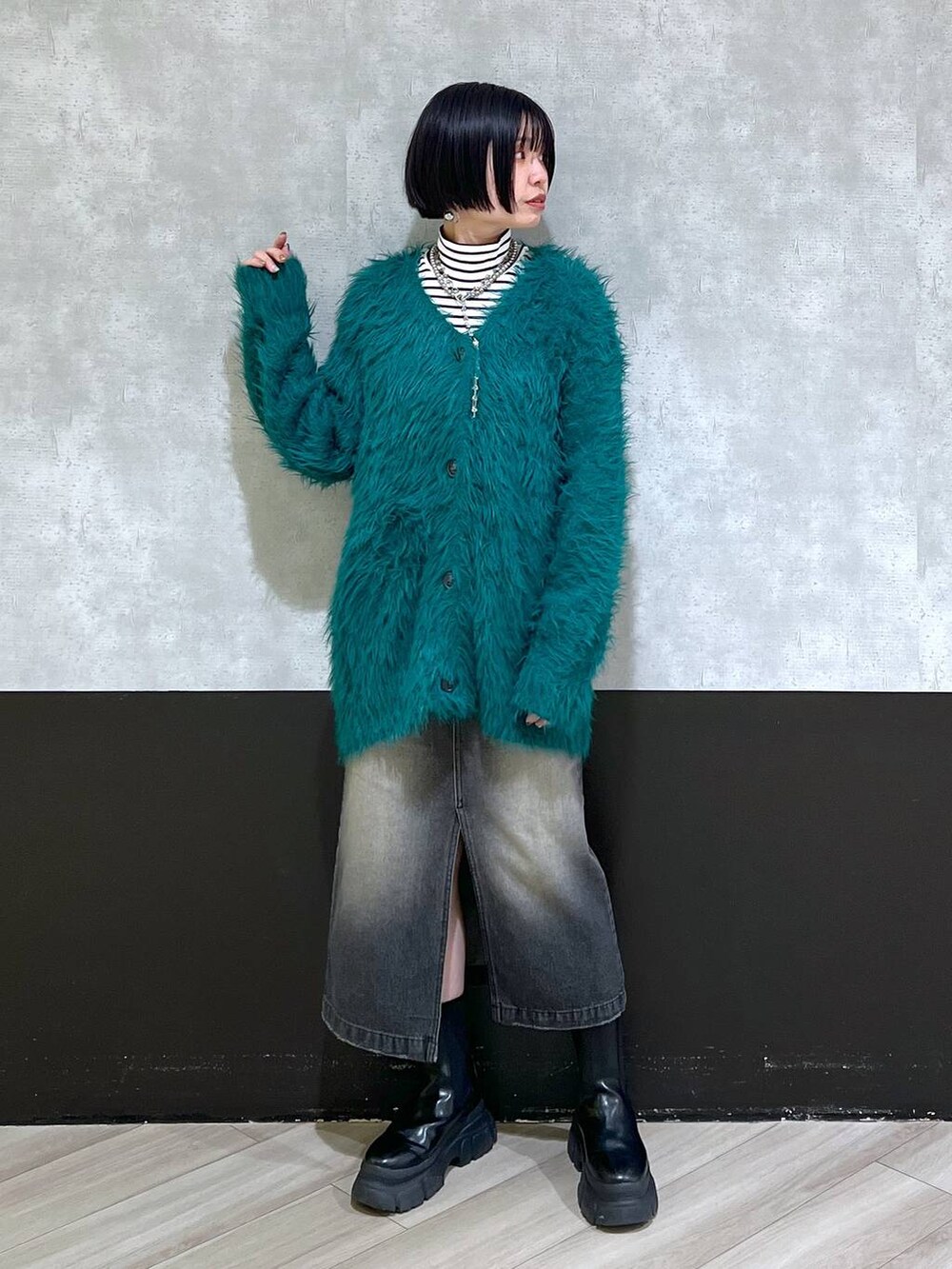 ブラック系のブーツ、グリーン系のカーディガン/ボレロ、ブラック系のスカートを着用したレディースの秋コーディネートの9枚目の写真