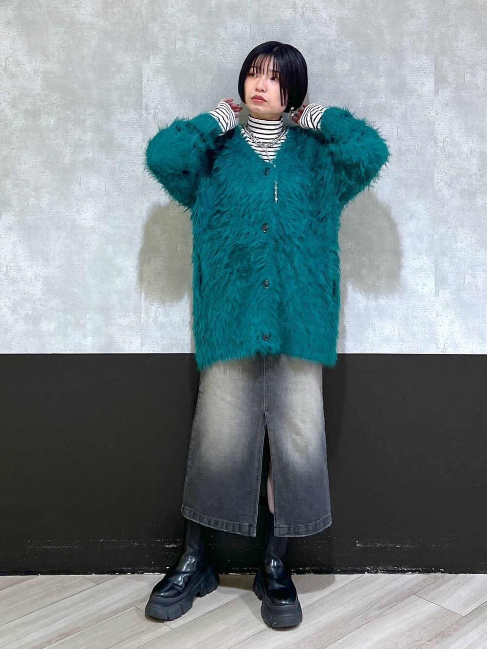 ブラック系のブーツ、グリーン系のカーディガン/ボレロ、ブラック系のスカートを着用したレディースの秋コーディネートの8枚目の写真