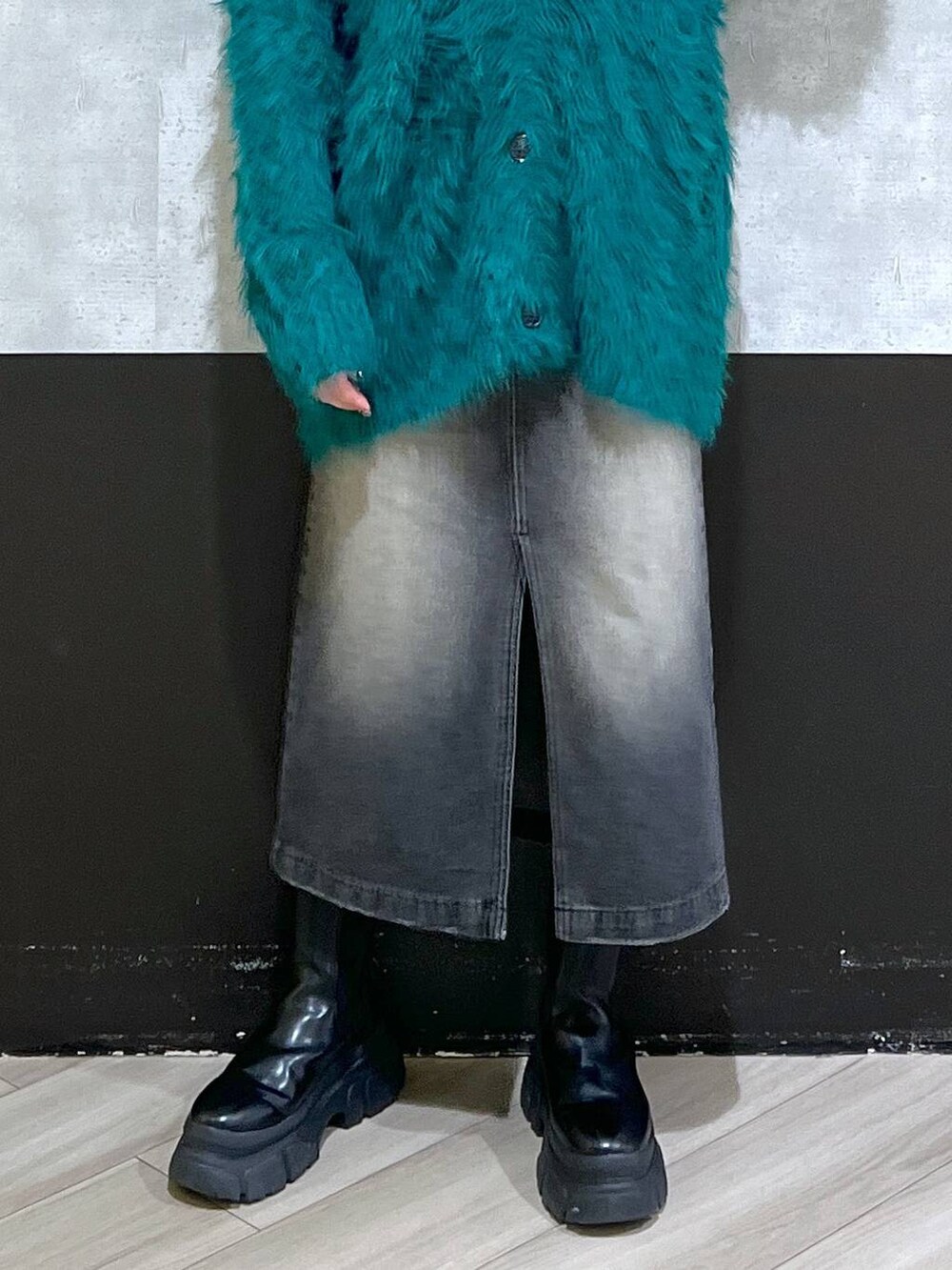 ブラック系のブーツ、グリーン系のカーディガン/ボレロ、ブラック系のスカートを着用したレディースの秋コーディネートの6枚目の写真