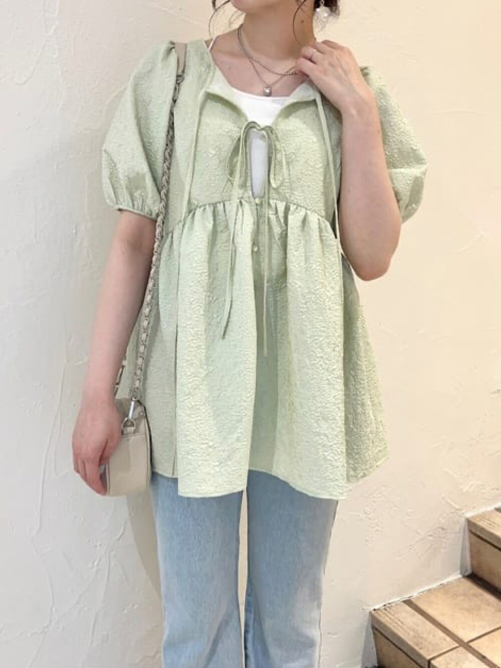 グリーン系のシャツ/ブラウス、ブルー系のデニムパンツ、ホワイト系のサンダルを着用したレディースの夏コーディネートの3枚目の写真