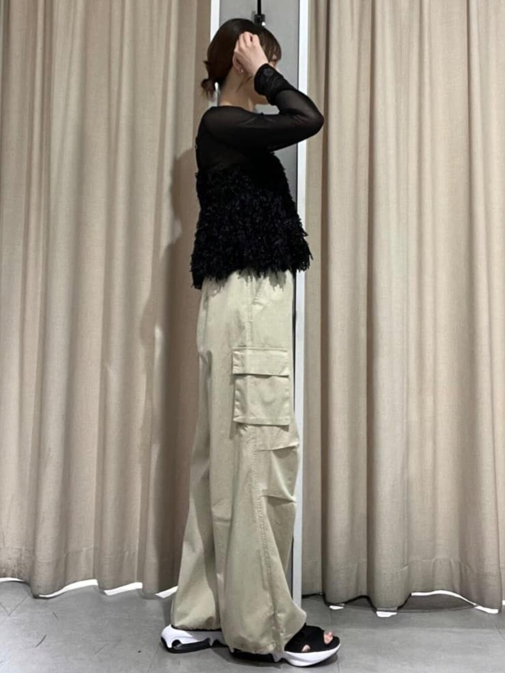 ブラック系のアンサンブル、ベージュ系のカーゴパンツを着用したレディースの秋コーディネートの2枚目の写真