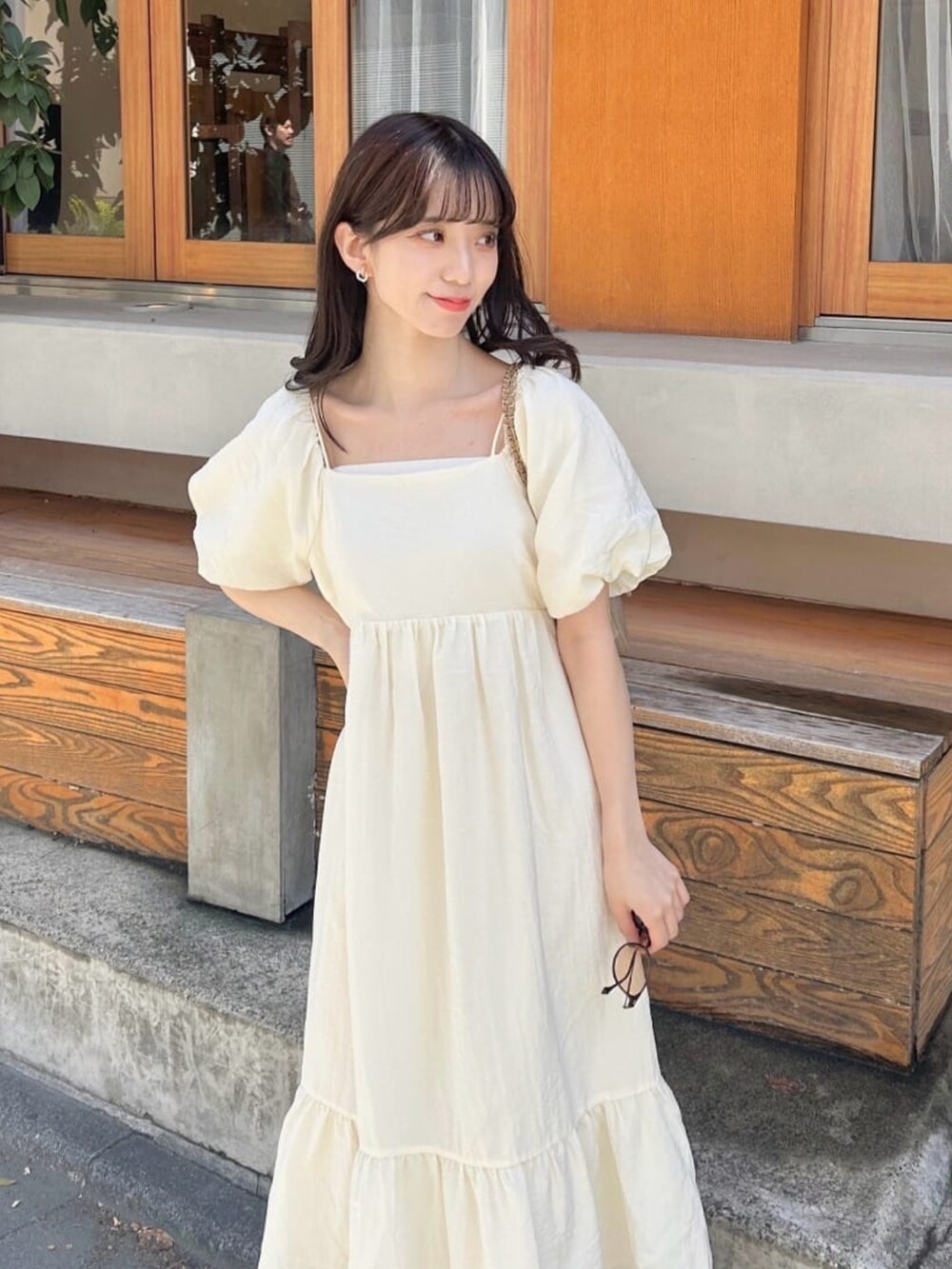 ブラック系のサンダル、ホワイト系のワンピースを着用したレディースの夏コーディネートの3枚目の写真